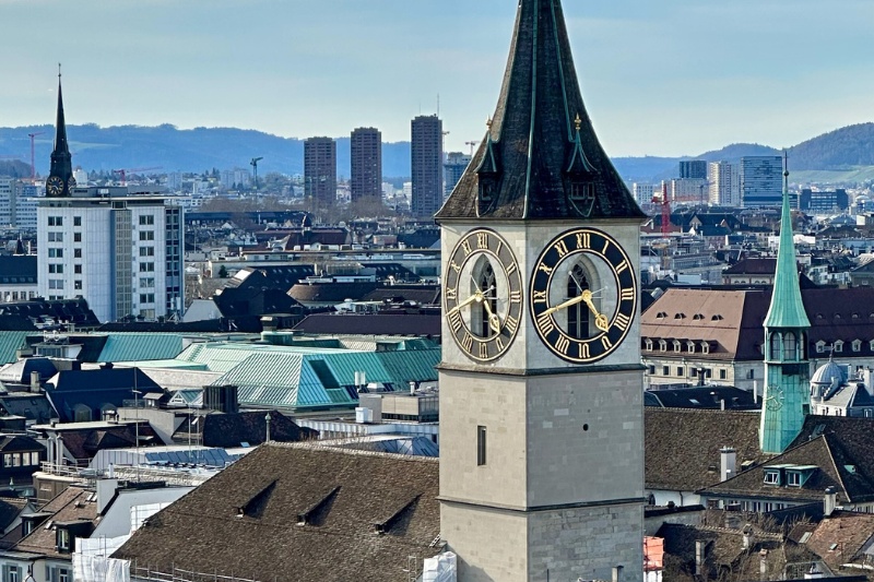View of St. Peter’s Church clock tower rising above the Zurich city skyline in Switzerland.