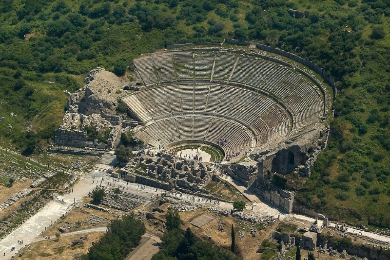 Aerial view of the massive Great Theater in Ephesus, Turkey, showcasing the preserved semi-circular seating and surrounding ruins.