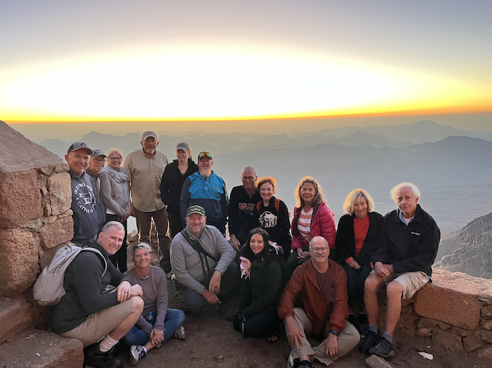 A group sits on a ledge overlooking the area from above