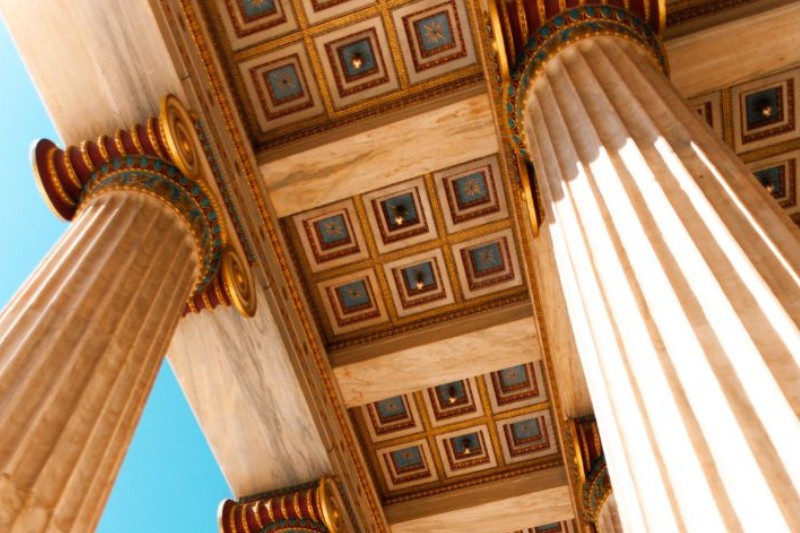 Close-up view of classical Greek columns and ornate ceiling details.