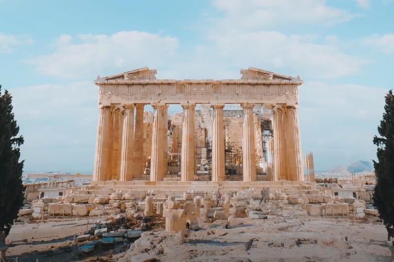 The Parthenon ruins in Athens, Greece, with tall columns and blue sky.