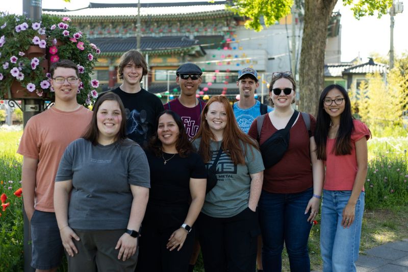 Group of tourists standing in front of Gwanghwamun Gate, the main entrance to Gyeongbokgung Palace in Seoul, South Korea.
