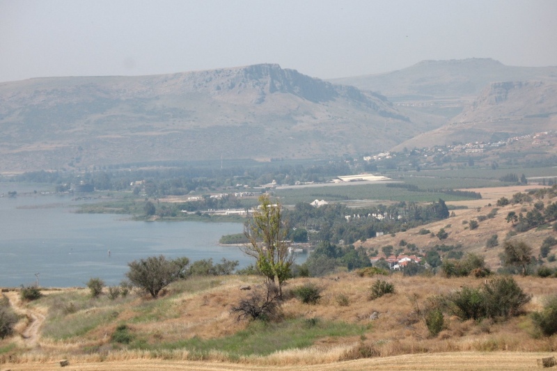 Scenic view of the Sea of Galilee with rolling hills, farmland, and a peaceful shoreline in northern Israel.