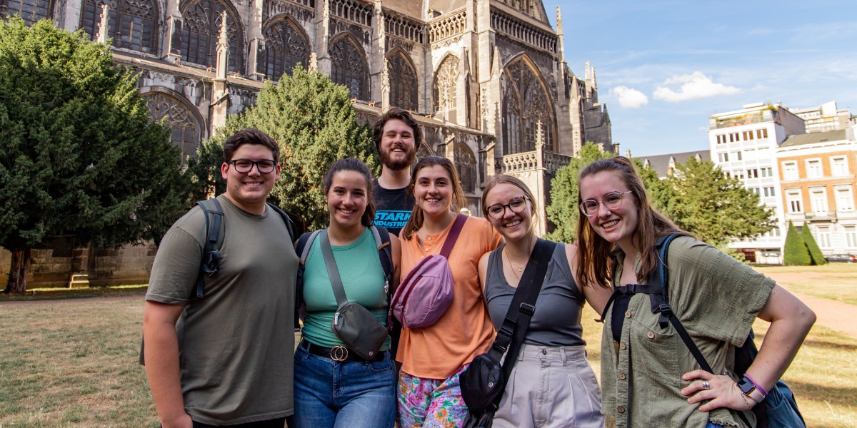 http://Group%20of%20college%20students%20posing%20in%20front%20of%20a%20Gothic-style%20cathedral%20on%20a%20sunny%20day%20in%20Europe